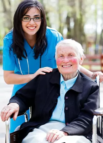 Female attendant helping an elderly man at home
