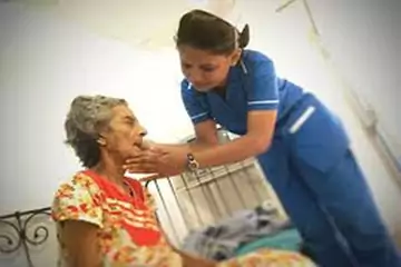 Caregiver supporting an elderly woman at home
